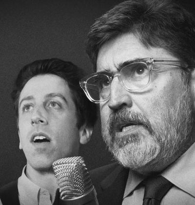 Actors Simon Helberg and Alfred Molina perform into a microphone